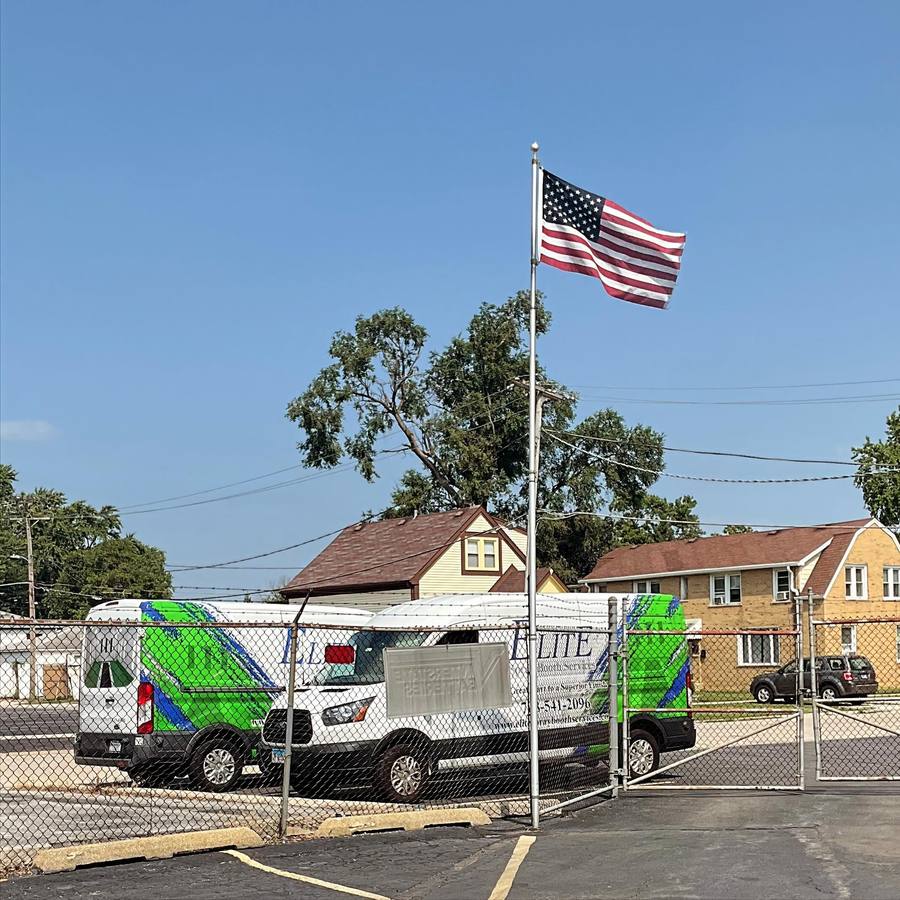 Elite vans parked by a flagpole